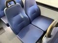 Two rows of blue upholstered seats inside a vehicle, with a textured surface and black armrests, designed for passenger comfort
