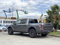 A 2019 Ford F-150 Raptor in gray with large off-road tires parked on a paved surface showcasing its robust design and rear lighting features