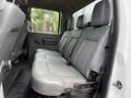 Rear interior seating of a 2015 Ford F-350 SD featuring gray leather upholstery and a three-seat configuration with seatbelts.