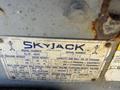 A metal identification tag from a 2010 Skyjack SJ III 4626 showing model information serial number and specifications including weight capacity and reach
