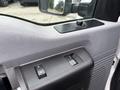 Close-up of the door panel in a 2013 Ford F-250 SD featuring power window controls and a textured surface