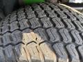 Tread pattern of a tire from a 2021 John Deere 1575 showing deep grooves and wear on the rubber surface