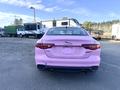 A pink 2020 Jaguar XE viewed from the back showcasing its sleek design and dual exhaust pipes