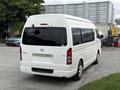 A white 2009 Toyota Hiace van seen from the rear with tinted windows and a clear tailgate design