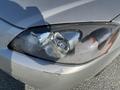 A silver 2006 Pontiac G6 with a close-up view of its front headlight showing condensation inside the lens and a small area of damage on the bumper