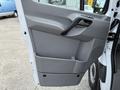 A gray interior van door of a 2012 Mercedes-Benz Sprinter with a handle and storage compartment visible