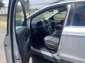 A silver 2015 Ford Escape with an open driver's side door revealing the interior and steering wheel