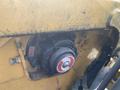 A close-up of a 2010 Vermeer Corporation BC1200XL machine component featuring a black and red circular part with visible wear and debris on a yellow surface