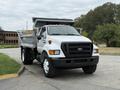 2004 Ford F-750 dump truck with a silver cargo bed and black grille parked on a roadway