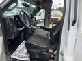 Interior view of a 2020 Chevrolet Express showing the driver's seat and dashboard with controls and accessories