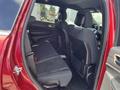 Interior view of a 2015 Jeep Grand Cherokee showcasing the rear seating area with two rows of seats in black fabric upholstery