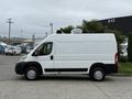 A white 2020 RAM Promaster van is parked with its side profile visible showcasing its sleek design and high roof