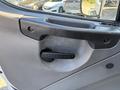 A close-up of the door handle and window crank of a 2006 Freightliner M2 106 truck interior