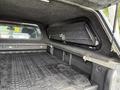 Interior of a 2018 Chevrolet Colorado showing a truck bed with a textured floor and an access panel in the wall of the truck bed shell
