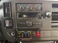 Interior dashboard of a 2020 Chevrolet Express featuring audio controls climate knobs and various buttons for vehicle functions