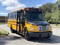 A 2011 Freightliner B2 school bus with a yellow exterior and a black front, featuring an open door and several lights on the roof