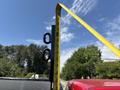 A measuring tape extended vertically next to a metal post with two loops attached on the top of a 2013 RAM 2500 truck