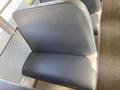 A gray padded bus seat inside a school bus showing the smooth surface and simple design typical of a Thomas Saf-T-Liner HDX from 2006