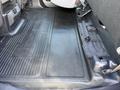 Interior view of the floor area of a 2024 Ford F-550 showing textured rubber mat and storage compartments