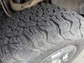 Close-up of a rugged tire tread on a 2014 Ford F-150 showing deep grooves and worn texture designed for off-road traction