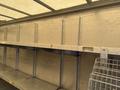 A 2012 Ford Econoline van with a spacious interior featuring metal shelving and hanging hooks for storage