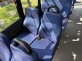 Two blue upholstered seats with seatbelts, positioned in the interior of a vehicle, featuring a gray floor and a visible fastening mechanism for the seatbelts