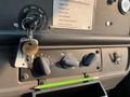 A 2007 Freightliner B2 dashboard with ignition key in the ignition, control knobs for wipers and fans, and a green pencil resting on the console