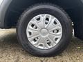 A close-up of a silver alloy wheel on a 2021 Ford Transit-350 featuring a Nokian tire with a textured tread pattern