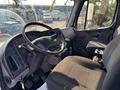 Interior of a 2016 Freightliner M2 106 featuring a driver seat steering wheel and dashboard with various controls and instruments