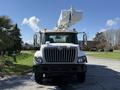 A white 2008 International 7500 truck with a raised aerial lift attachment and orange safety lights on the roof
