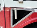 A red 2012 International 7300 Workstar with a metallic triangular access panel on the side showcasing a sturdy design and functional features