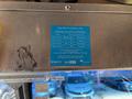 A blue information plaque mounted inside a vehicle warning about electricity hazards and safety guidelines