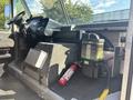 A 2012 Ford E-450 interior showing the dashboard steering wheel and cabin controls alongside a fire extinguisher and storage compartment