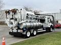 A 2013 International Workstar 7500 truck with a large vacuum system and multiple pipes attached to the rear for industrial cleaning purposes