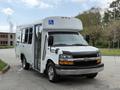 A 2013 Chevrolet Express van with a wheelchair accessible ramp on the side and a white exterior