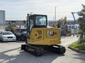A yellow 2022 Caterpillar 306 excavator features tracks and a cabin with a large rear engine compartment and a prominent CAT logo on the back