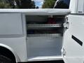 A white 2021 RAM 5500 service truck with an open utility box showing shelves containing various tools and equipment