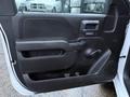 A close-up of the interior door panel of a 2017 GMC Sierra 3500HD featuring a black armrest door handle and a small window control panel