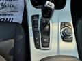 Close-up of the gear shift and control panel in a 2013 BMW X3 featuring a joystick controller and various driving mode buttons
