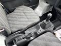 Interior view of a 2008 Suzuki Carry showing the driver's seat gear shift and handbrake in a gray patterned fabric surface