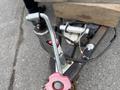 A close-up of a 2016 Continental cargo trailer's tongue jack with a crank handle and a safety latch visible