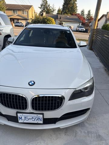 A 2011 BMW 7-Series sedan in white with a distinctive kidney grille and sporty front design