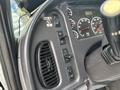 Interior dashboard controls of a 2013 Freightliner 114SD including various buttons and gauges for operation and functions