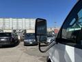 A 2020 Chevrolet Express van with a side mirror in focus while parked among other vehicles in a lot