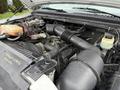 The image shows the engine compartment of a 2000 Ford F-450 with visible components like the air intake hose battery and various fluids in reservoirs