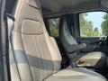 Two gray leather seats inside a 2021 Chevrolet Express van with one seat adjusted forward and the other reclined slightly