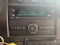 2020 Chevrolet Express dashboard featuring a digital radio display with FM stations and a control panel for settings and tuning