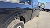 A black 2016 Ford F-150 with visible scratches and dents on the side panel and tire area