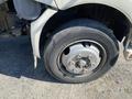 A close-up view of the front wheel of a 2014 Hino 195 with a black tire and a silver metallic wheel rim