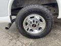 A close-up of a shiny chrome wheel and tire from a 2022 GMC Savana with a black Goodyear tire and a prominent GMC logo in the center